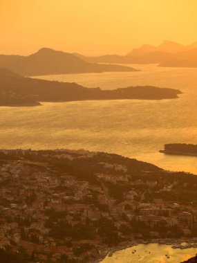 Deniz ve küçük adalar üzerinde gün batımı manzarası, arka plan için uygun bulanık ve dumanlı arka plan