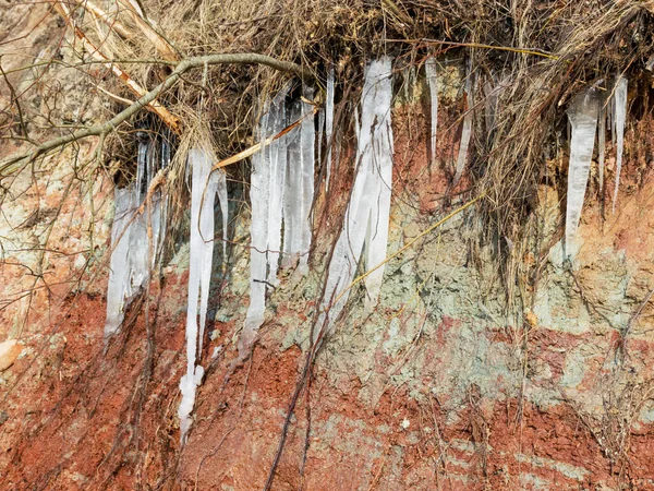 Foto Mit Weißen Eiszapfen Den Roten Lehmwänden Frühlingslandschaft Der Küste — Stockfoto
