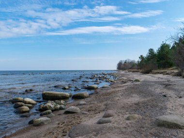 Güneşli bir günde birçok taşlı mavi deniz manzarası, Kaltene kıyısı, Letonya