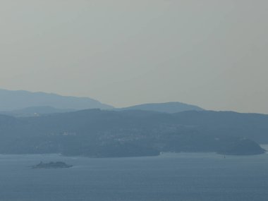 Deniz ve küçük adalar üzerinde gün batımı manzarası, arka plan için uygun bulanık ve dumanlı arka plan