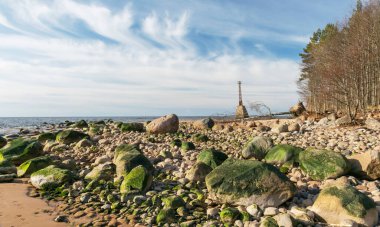 Sahilde yeşil taşlar ön planda Kumrags deniz feneri arka planda, Vidzeme kıyısı, Baltık Denizi, Letonya