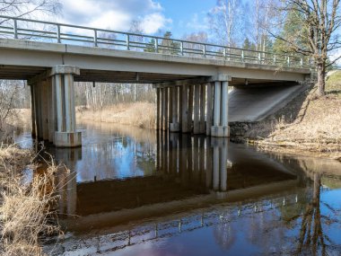 Güneşli bahar manzarası ile nehir üzerinde bir köprü Seda, Letonya