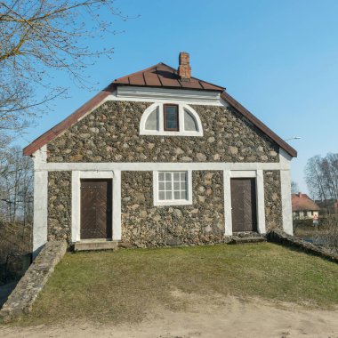 Güzel gri taş ev. Pencereler ve kapılar beyaz aksanlı.