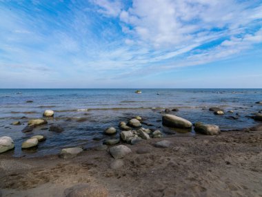Güzel deniz manzarası, güzel bulutlar, bir sürü kaya. Deniz kenarında ilkbahar, Kaltene kıyısı, Letonya
