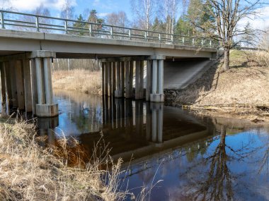 Güneşli bahar manzarası ile nehir üzerinde bir köprü Seda, Letonya