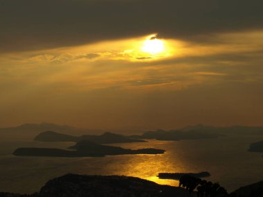 Deniz ve küçük adalar üzerinde gün batımı manzarası, arka plan için uygun bulanık ve dumanlı arka plan