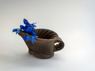 Dekoratif kil bardaklı resim, mavi çiçek aksanı, el yapımı, seramik, arka planda bardak, çömlek.