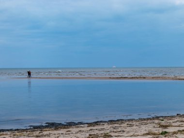 Güneşli bir günde güzel bir deniz manzarası, Cape Kolka, Letonya yakınlarında kara bulutlar.