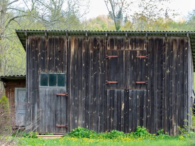Bahçede basit bir ahşap barakayla çekilmiş bir resim.