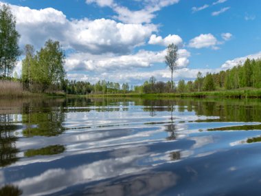 Baharda güzel bir nehri olan manzara, Sudaki bulut yansımaları, Seda Nehri, Letonya