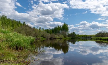 Baharda güzel bir nehri olan manzara, Sudaki bulut yansımaları, Seda Nehri, Letonya