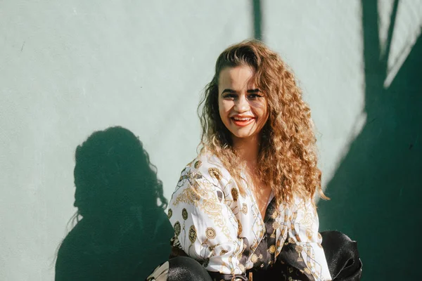 Modern urban blonde curly girl possing on a tennis court. — Stock Photo, Image