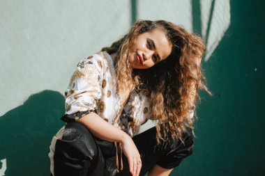 Modern şehirli sarışın kıvırcık kız tenis kortunda takılıyor..