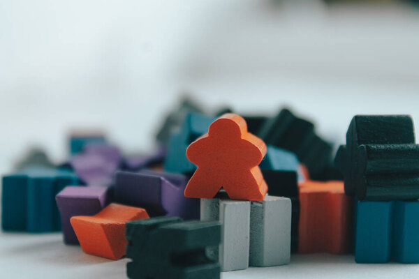 Stacked meeples prepared for a game of board game. Army of meeples colored wooden figures with human shape. To play.