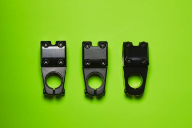 BMX direksiyon için üç gövde parlak yeşil arka planda yatıyor. Bisikletler için parçalar. Ekstrem sporlar.