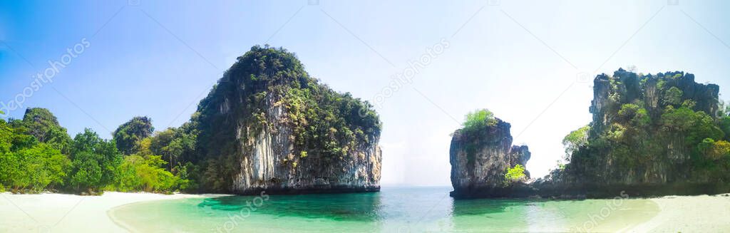 Island beach with limestone rocks and long tail boats