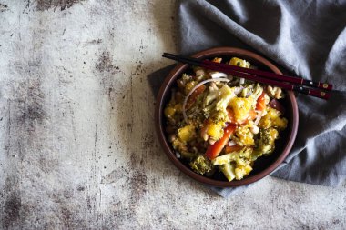 Kil tabakta Kore baharatlı salatası ve gri arka planda çubuklar.