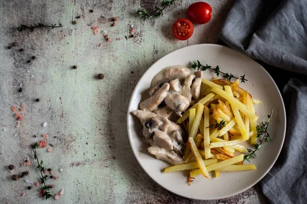 Hearty lunch: chicken and mushroom Fricassee with French fries