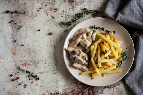 Mantarlı tavuk ve patates kızartması güzel bir tabakta.