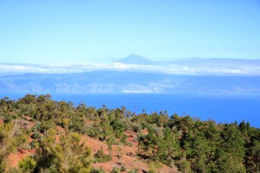 La Gomera 'daki Agulo' daki Mirador de Abrante 'de volkanik kökenli renkli kırmızı toprak ve kum tepeleri Tenerife' deki Teide volkanı ile Atlantik Okyanusu 'nun kuzeyine bakıyor.