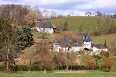 Almanya 'nın yeşil manzarasına gömülü güzel, yarı ahşap bir ev.