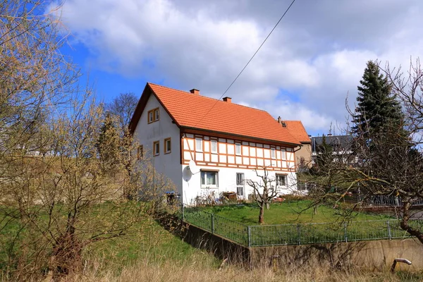 Almanya 'nın yeşil manzarasına gömülü güzel, yarı ahşap bir ev.