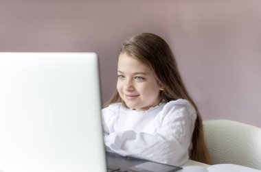 Uzaktan öğrenme çevrimiçi eğitim. Evde kal. Covid-19 Coronavirus ve evden öğrenme, sosyal mesafe. Hasta kız evde dijital tablet dizüstü bilgisayarla ders çalışıyor ve ödev yapıyor..