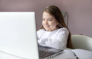 Uzaktan öğrenme çevrimiçi eğitim. Evde kal. Covid-19 Coronavirus ve evden öğrenme, sosyal mesafe. Hasta kız evde dijital tablet dizüstü bilgisayarla ders çalışıyor ve ödev yapıyor..