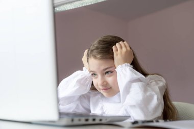 Uzaktan öğrenme çevrimiçi eğitim. Evde kal. Covid-19 Coronavirus ve evden öğrenme, sosyal mesafe. Hasta kız evde dijital tablet dizüstü bilgisayarla ders çalışıyor ve ödev yapıyor..