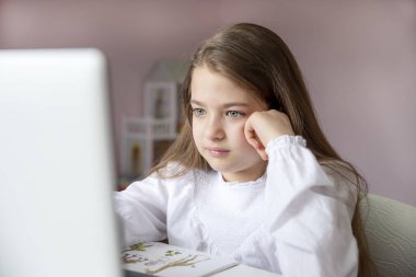 Uzaktan öğrenme çevrimiçi eğitim. Evde kal. Covid-19 Coronavirus ve evden öğrenme, sosyal mesafe. Hasta kız evde dijital tablet dizüstü bilgisayarla ders çalışıyor ve ödev yapıyor..