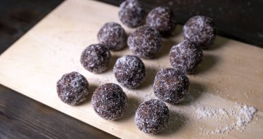 Tarih, ceviz, badem ve hindistan cevizli ev yapımı enerji topları. Sağlıklı tatlı yiyecekler. Uzay enerji toplarını beyaz bir arka planda bir kaseye kopyala. Ham enerji topları, tüm doğal ve sağlıklı ham enerji ısırıkları.