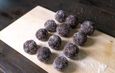 Tarih, ceviz, badem ve hindistan cevizli ev yapımı enerji topları. Sağlıklı tatlı yiyecekler. Uzay enerji toplarını beyaz bir arka planda bir kaseye kopyala. Ham enerji topları, tüm doğal ve sağlıklı ham enerji ısırıkları.