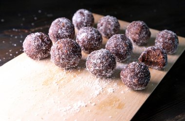 Tarih, ceviz, badem ve hindistan cevizli ev yapımı enerji topları. Sağlıklı tatlı yiyecekler. Uzay enerji toplarını beyaz bir arka planda bir kaseye kopyala. Ham enerji topları, tüm doğal ve sağlıklı ham enerji ısırıkları.