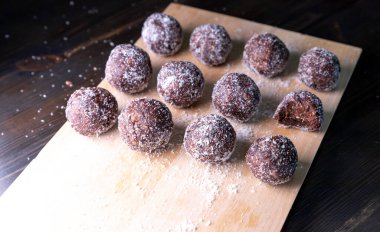 Tarih, ceviz, badem ve hindistan cevizli ev yapımı enerji topları. Sağlıklı tatlı yiyecekler. Uzay enerji toplarını beyaz bir arka planda bir kaseye kopyala. Ham enerji topları, tüm doğal ve sağlıklı ham enerji ısırıkları.