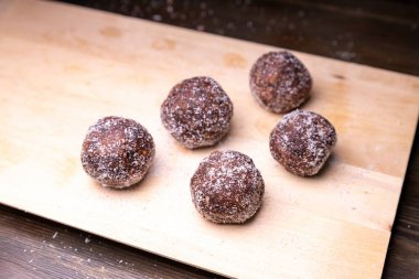 Tarih, ceviz, badem ve hindistan cevizli ev yapımı enerji topları. Sağlıklı tatlı yiyecekler. Uzay enerji toplarını beyaz bir arka planda bir kaseye kopyala. Ham enerji topları, tüm doğal ve sağlıklı ham enerji ısırıkları.