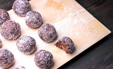 Tarih, ceviz, badem ve hindistan cevizli ev yapımı enerji topları. Sağlıklı tatlı yiyecekler. Uzay enerji toplarını beyaz bir arka planda bir kaseye kopyala. Ham enerji topları, tüm doğal ve sağlıklı ham enerji ısırıkları.