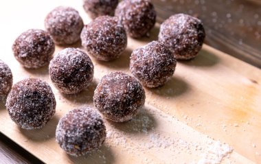 Tarih, ceviz, badem ve hindistan cevizli ev yapımı enerji topları. Sağlıklı tatlı yiyecekler. Uzay enerji toplarını beyaz bir arka planda bir kaseye kopyala. Ham enerji topları, tüm doğal ve sağlıklı ham enerji ısırıkları.