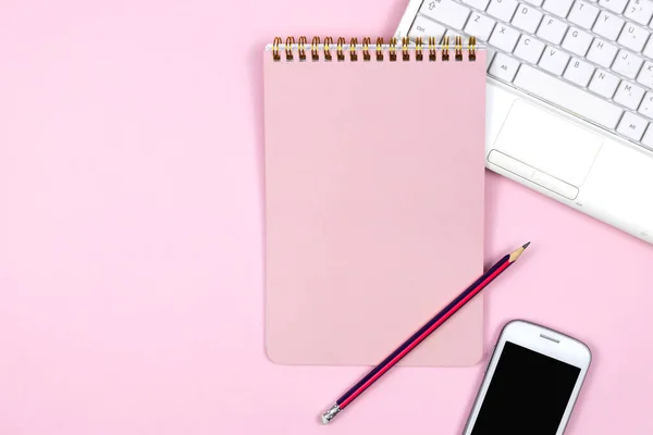 Flat lay home office desk. Women workspace with laptop, notebook,pink smart watch, pen with phone on pink background. Top view feminine background. Freelance concept. Top view with copy space, flat lay photography.