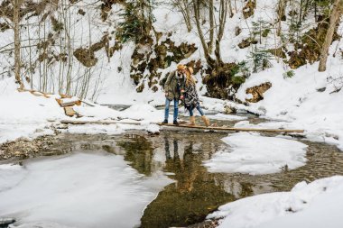 Birkaç gezgin engelleri aştı, kışın dağ nehri.
