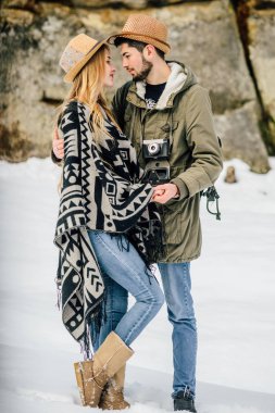 Bir çift kâşif, kış dağlarındaki vadi ve kayaların arka planında..