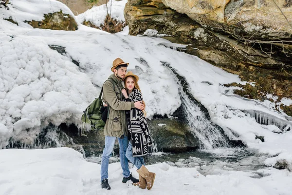 Liefdevolle Koppel Reizigers Tegen Achtergrond Van Een Bevroren Waterval Bergen — Stockfoto