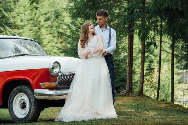Apacible elegante novio y novia en el fondo viejo coche de moda —  Fotos de Stock