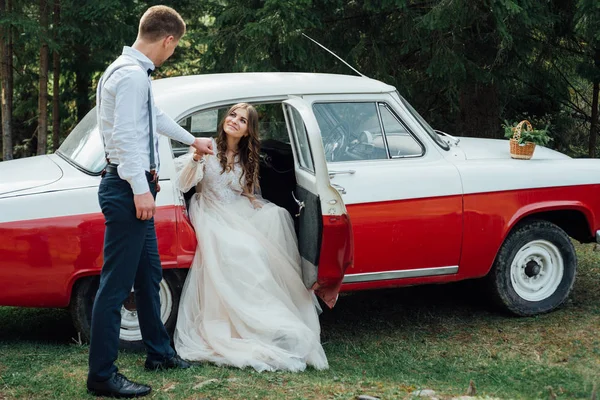 Brautpaar im Wald in der Nähe von Luxus-Hochzeitsauto — Stockfoto