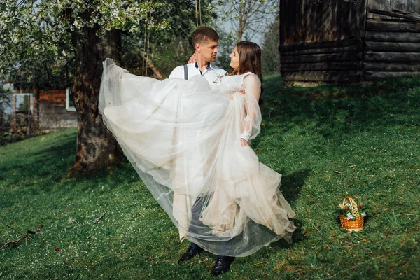Der Bräutigam trägt seine glückliche Braut auf dem Arm — Stockfoto