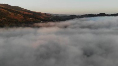 Güneş doğarken yoğun sisli güzel dağ manzarası.
