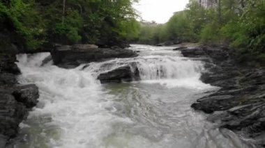 Öğleden sonra güneşinde güzel şelalesi olan bir dağ nehrinin havadan görünüşü