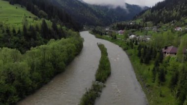 Sisli bir günde dağların ve nehrin havadan görünüşü. Drone 'un gözü dağ köyünde..