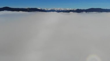 4K Havacılık manzarası. Dağlık bölgede bulutların üzerinde uçmak, tepeler ve odunlar.