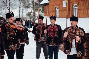 Kryvorivnia, Ukrayna - 7 Ocak 2019: Kryvorivnia 'lı ünlü hutzulian Koliadnyky Noel şarkıları söylüyor ve antik ahşap kilisenin etrafında yürüyor. Karpat dağlarının eski kış gelenekleri.
