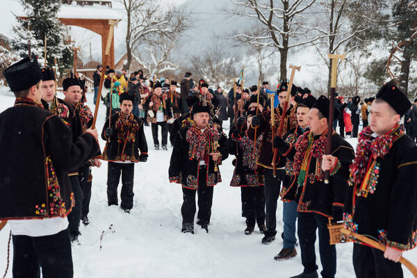 Kryvorivnia, Ukraine - January 7, 2019: Famous hutzulian Koliadnyky of Kryvorivnia singing Christmas carols and marching around ancient wooden church. Old winter traditions of Carpathian mountains.